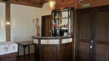 A room with a wooden cabinet, a table with a floral tablecloth, and a door labeled "SAIDA".