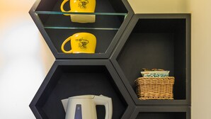 A hexagonal shelf unit with a kettle, two water bottles, and a basket. - Bee House by Cosmos Creation-Taipei Main Station (Taipei)