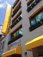 Een gebouw met een bord waarop 'Bee House' staat en een ander bord met de tekst 'Bee Relax, Bee You'.