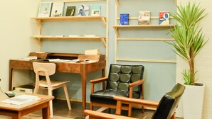 A cozy room with wooden furniture, a desk, and shelves with books and decorative items. - Bee House by Cosmos Creation-Taipei Main Station (Taipei)