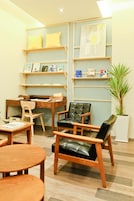 Een gezellige kamer met houten meubels, een bureau en planken met boeken en decoratieve objecten.