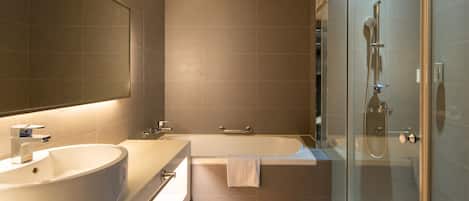 Uma casa de banho moderna com um espelho grande, uma sanita redonda, uma banheira e uma área de duche com parede de vidro.