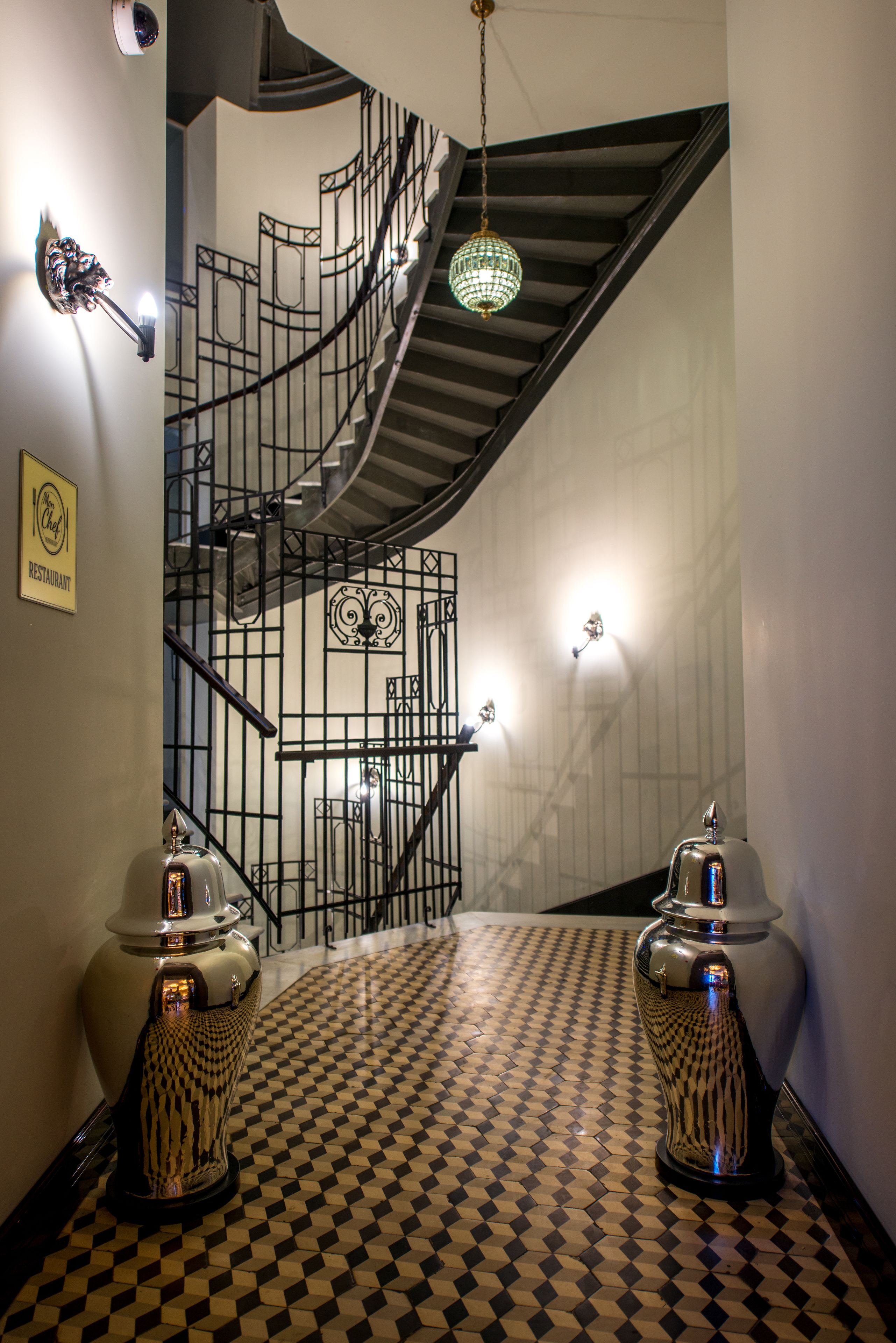 Una escalera con suelo a cuadros, un aplique de pared y un adorno mural.
