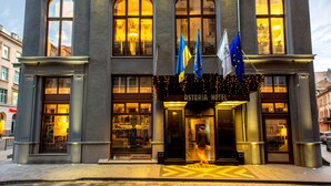 A hotel with a grand entrance, large arched windows, and multiple flags.