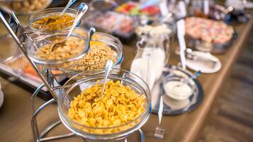 A buffet with various food items in clear glass bowls, including cereal and other dishes.