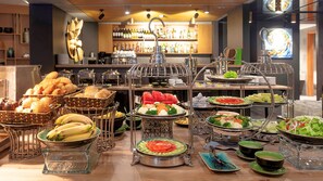 Buffet com diversos alimentos e área de bar com garrafas.