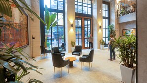 A spacious lobby with high ceilings, large windows, and modern seating arrangements. - Flower Garden Hotel (Hanoi)