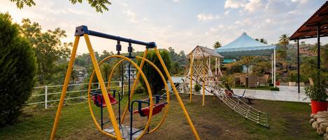 A playground with swings and a climbing structure.