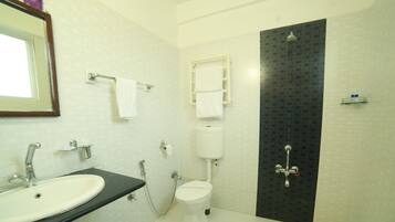 Un baño con lavamanos, inodoro y ducha.