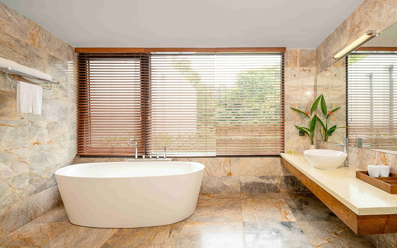 A modern bathroom with a freestanding bathtub, a vanity with a sink, and a large mirror.