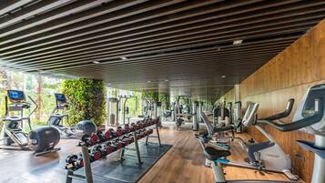 A modern gym with various exercise equipment, including treadmills, ellipticals, and free weights.