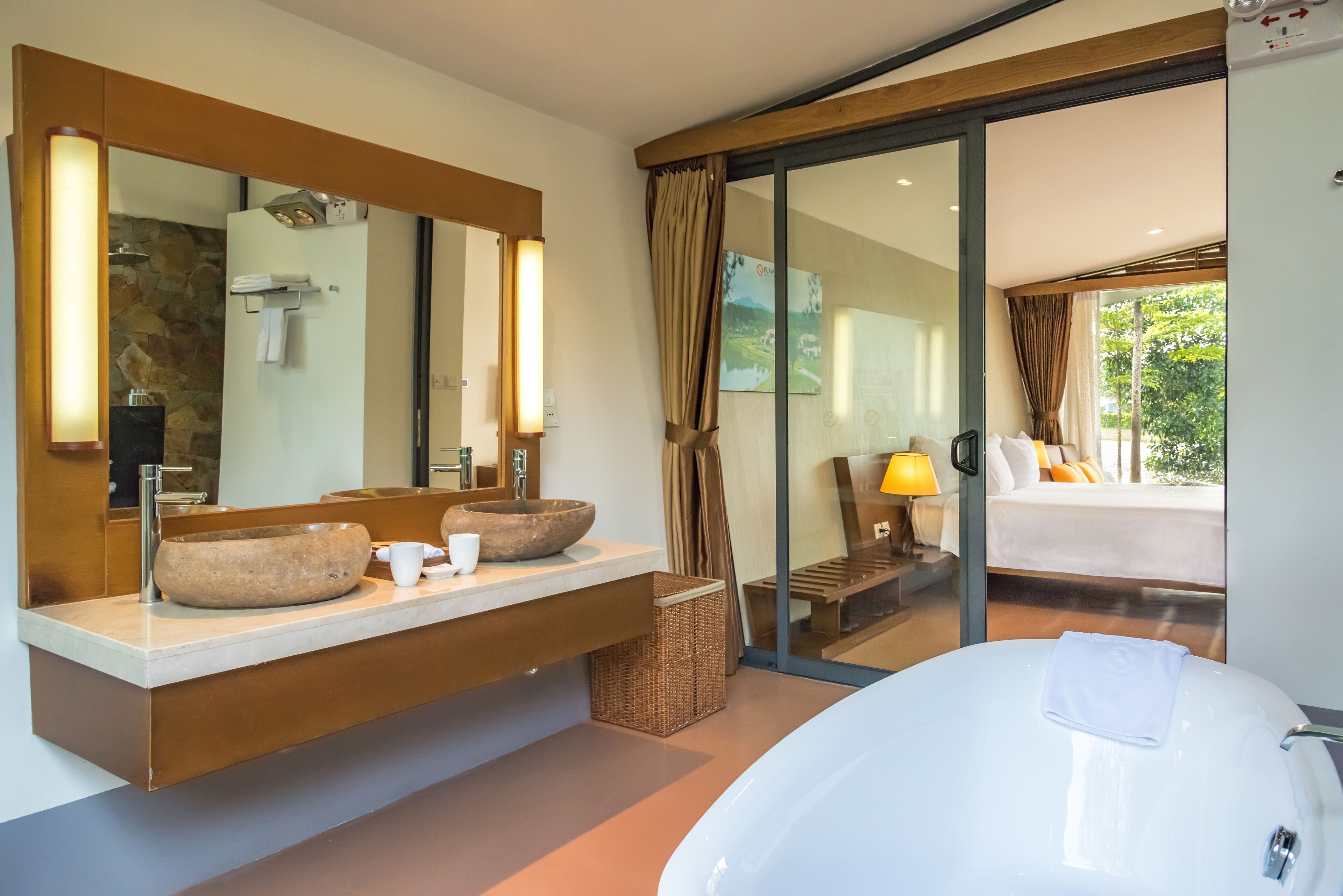 Une salle de bain moderne avec une grande baignoire, un lavabo en pierre et un grand miroir.
