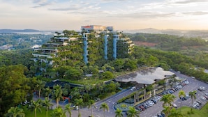 A hotel with multiple floors, lush greenery, and a parking area. - Flamingo Dai Lai Resort - Managed by Flamingo Hotels & Resorts (Xuan Hoa)