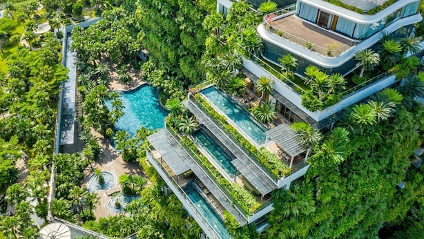 A multi-story hotel with a rooftop pool, lush greenery, and a modern architectural design. - Flamingo Dai Lai Resort - Managed by Flamingo Hotels & Resorts (Xuan Hoa)