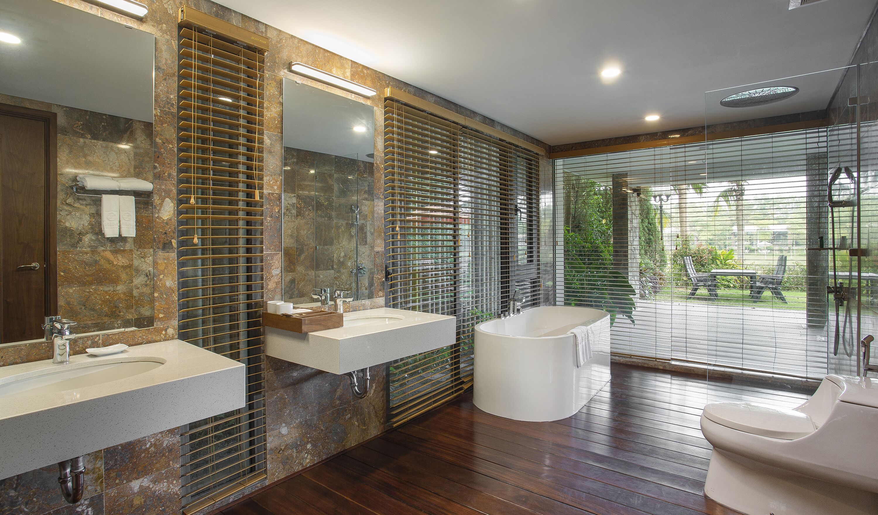 A modern bathroom with two sinks, a large mirror, and a bathtub.