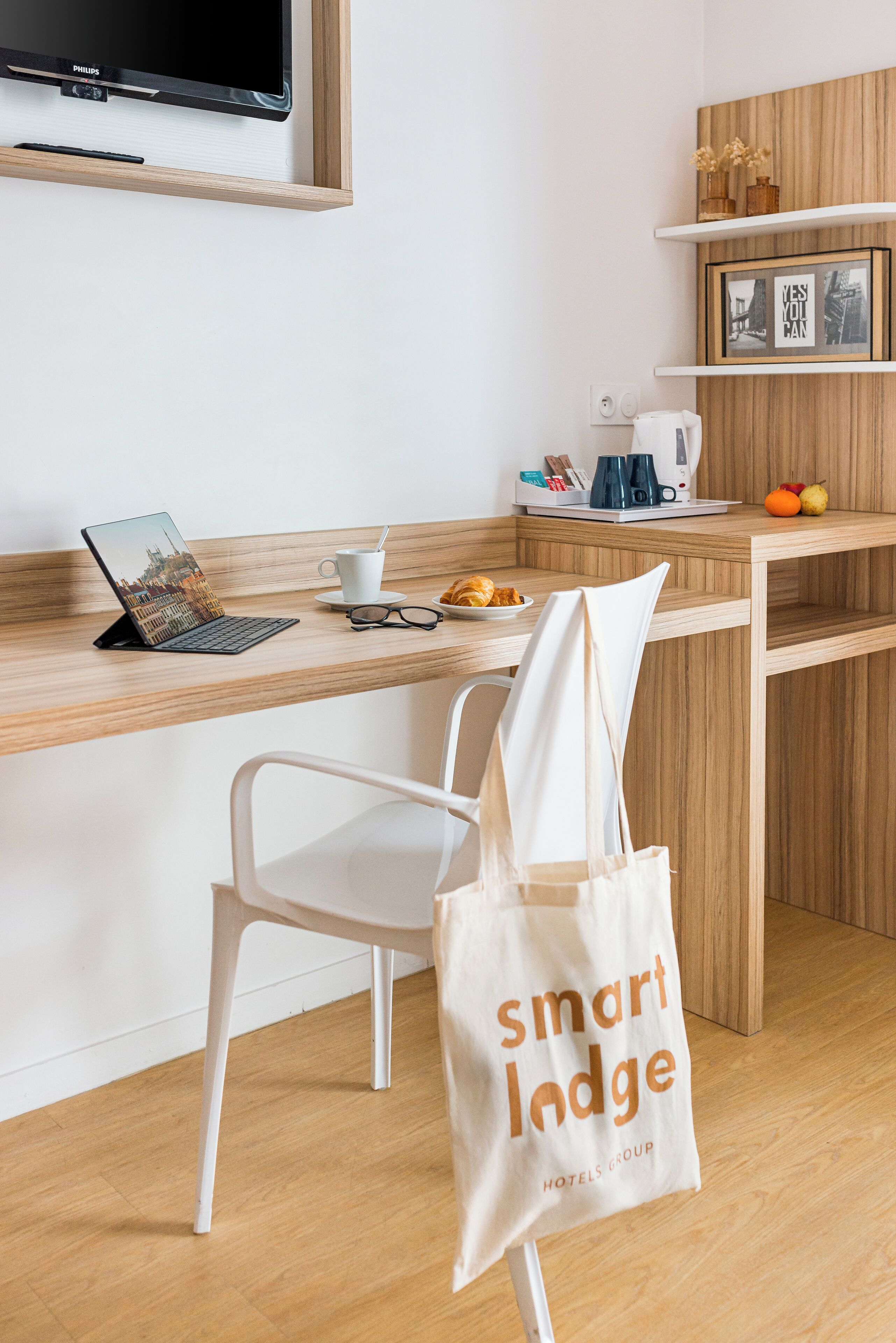 Una cocina moderna con encimera de madera, una computadora portátil, una cafetera y una silla blanca.