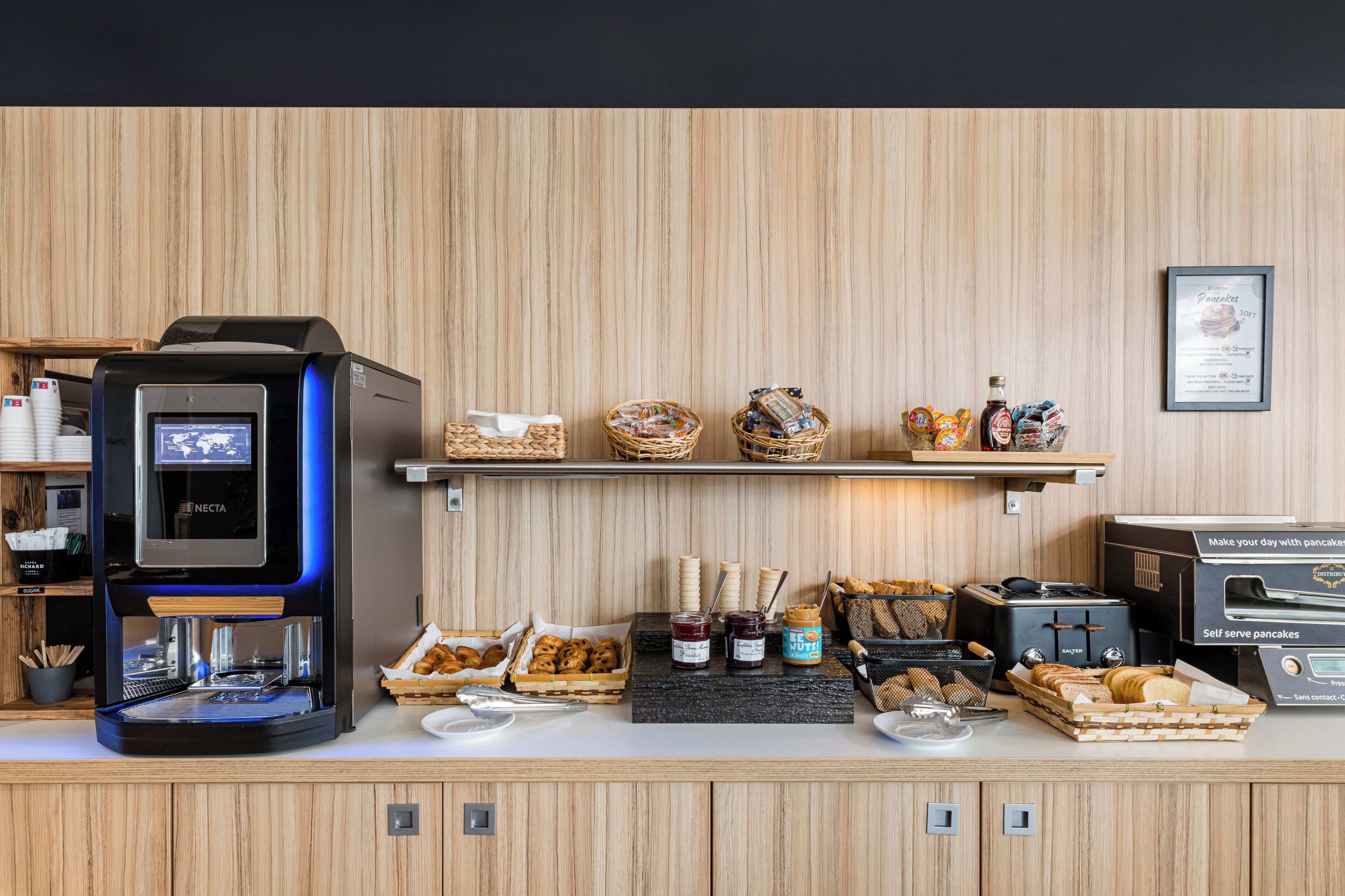 Montaje de bufé de desayuno con una máquina de café, diferentes alimentos y salsas.