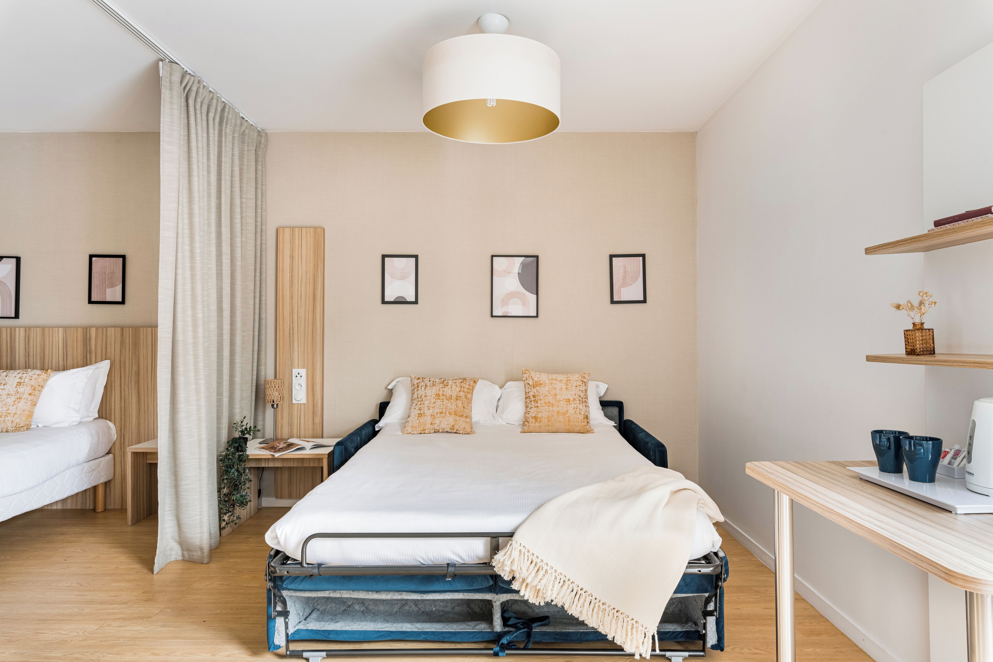 Une chambre d’hôtel moderne, dotée d’un grand lit, d’un bureau et d’une table de chevet.