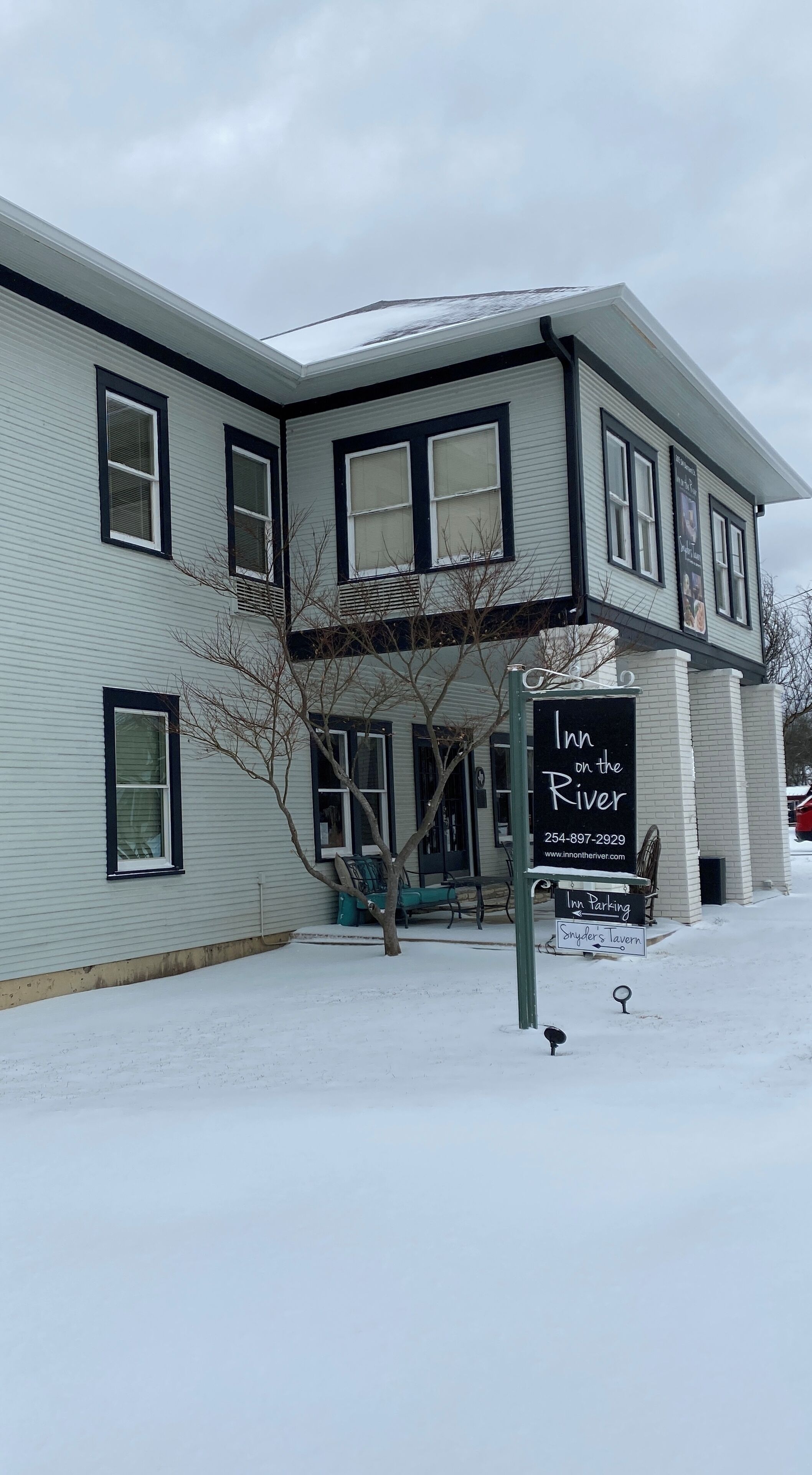 A two-story building with a sign for 'Inn on the River' and 'Snyder's Tavern'.
