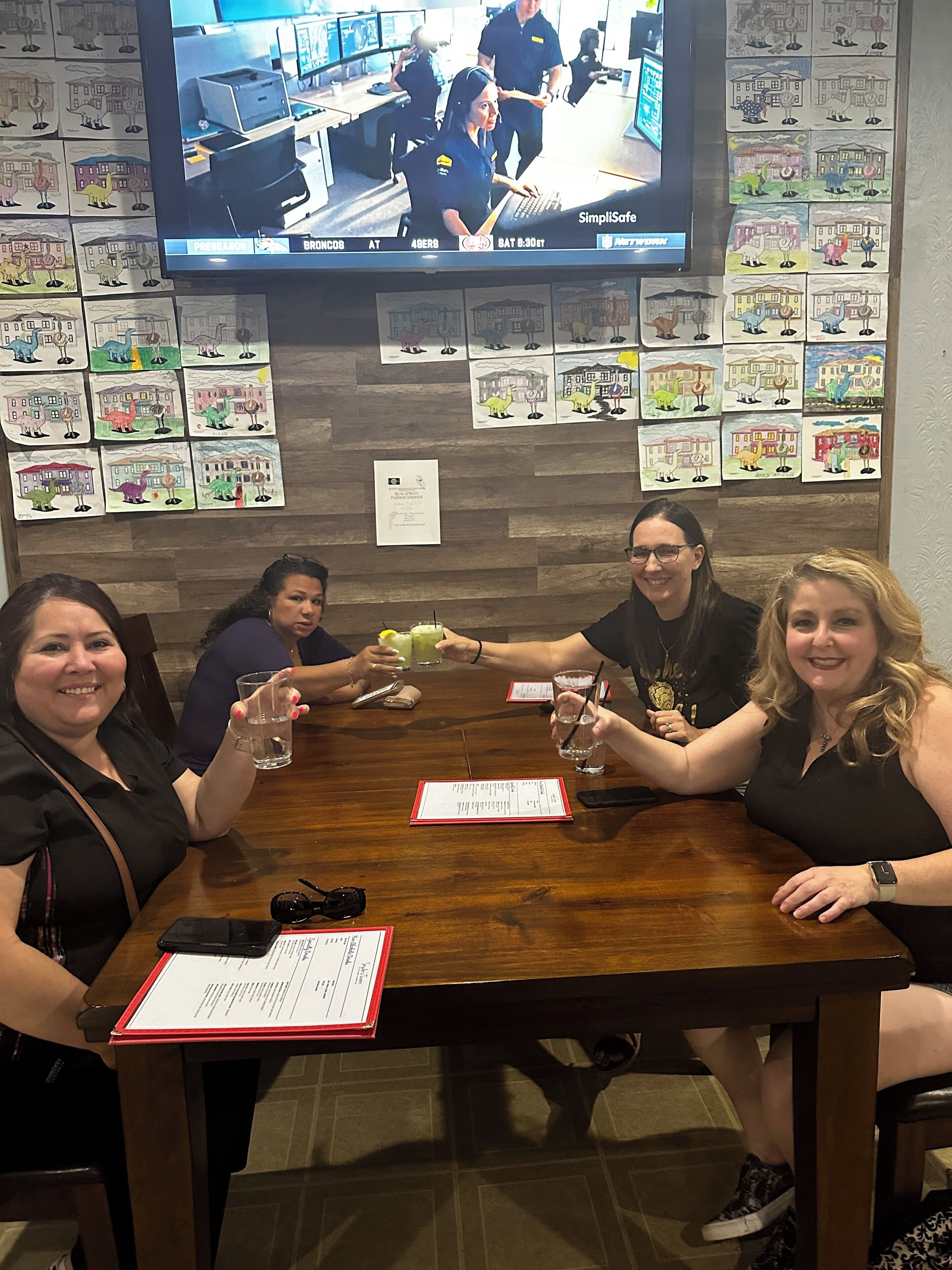 A group of people seated around a wooden table with a menu in front of them.