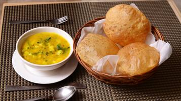 Un bol de soupe et un panier de pain posés sur un set de table en fibres tressées.