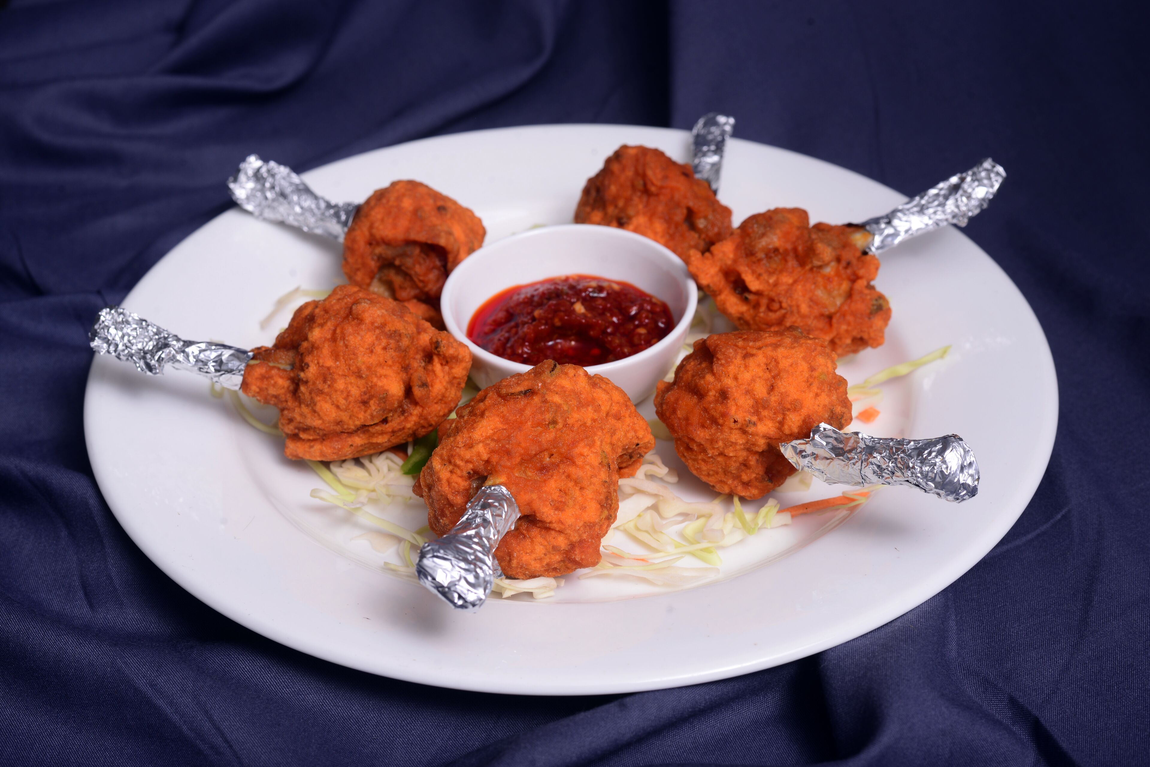 Un plato de alitas de pollo con salsa para mojar.