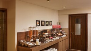 A buffet breakfast self-service area with various food items and utensils. - The Hawaii Comforts (Panaji)