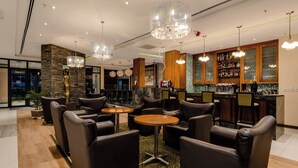 A bar area with leather seating, a bar counter, and a wine rack. - Protea Hotel by Marriott Benin City Select Emotan (Benin City)
