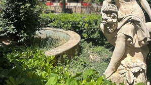 Une statue dans un jardin, avec un bâtiment en arrière-plan.