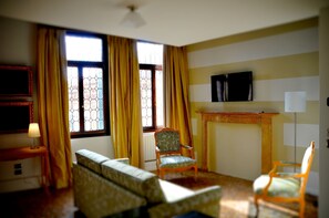 Una sala de estar con sofá, sillones, televisor y chimenea.