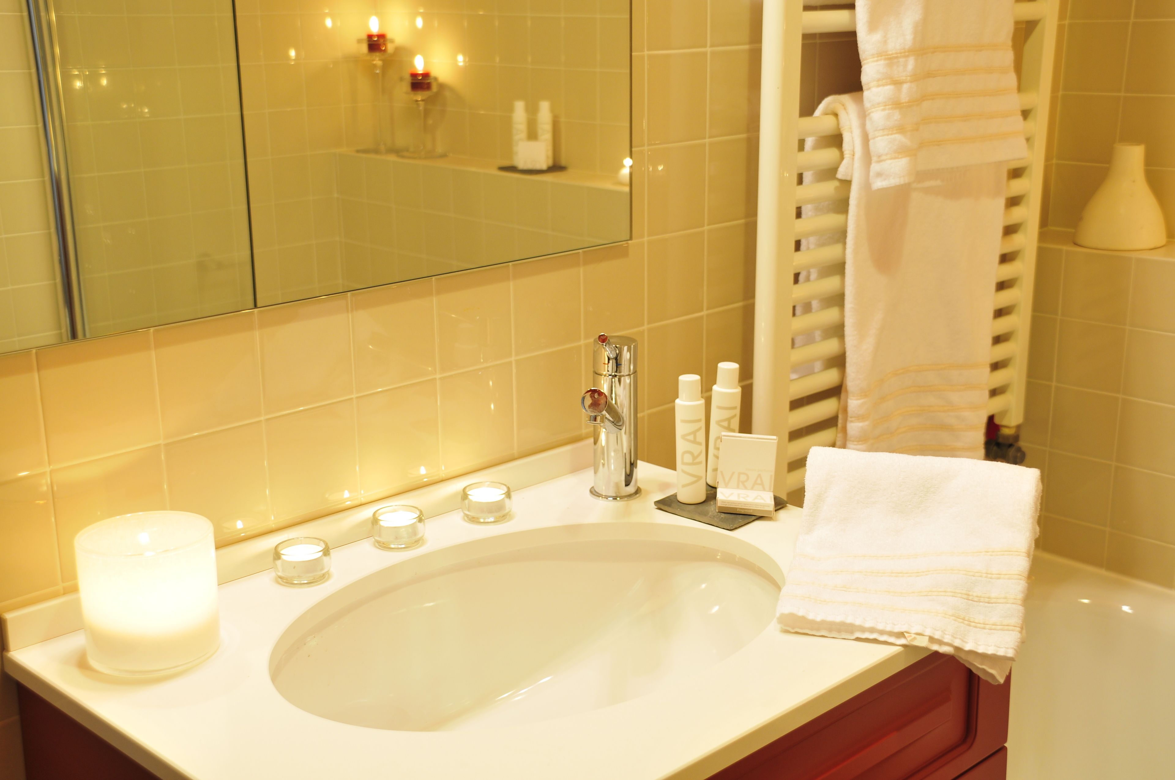 Un baño con un lavamanos grande, un espejo y un perchero para toallas.