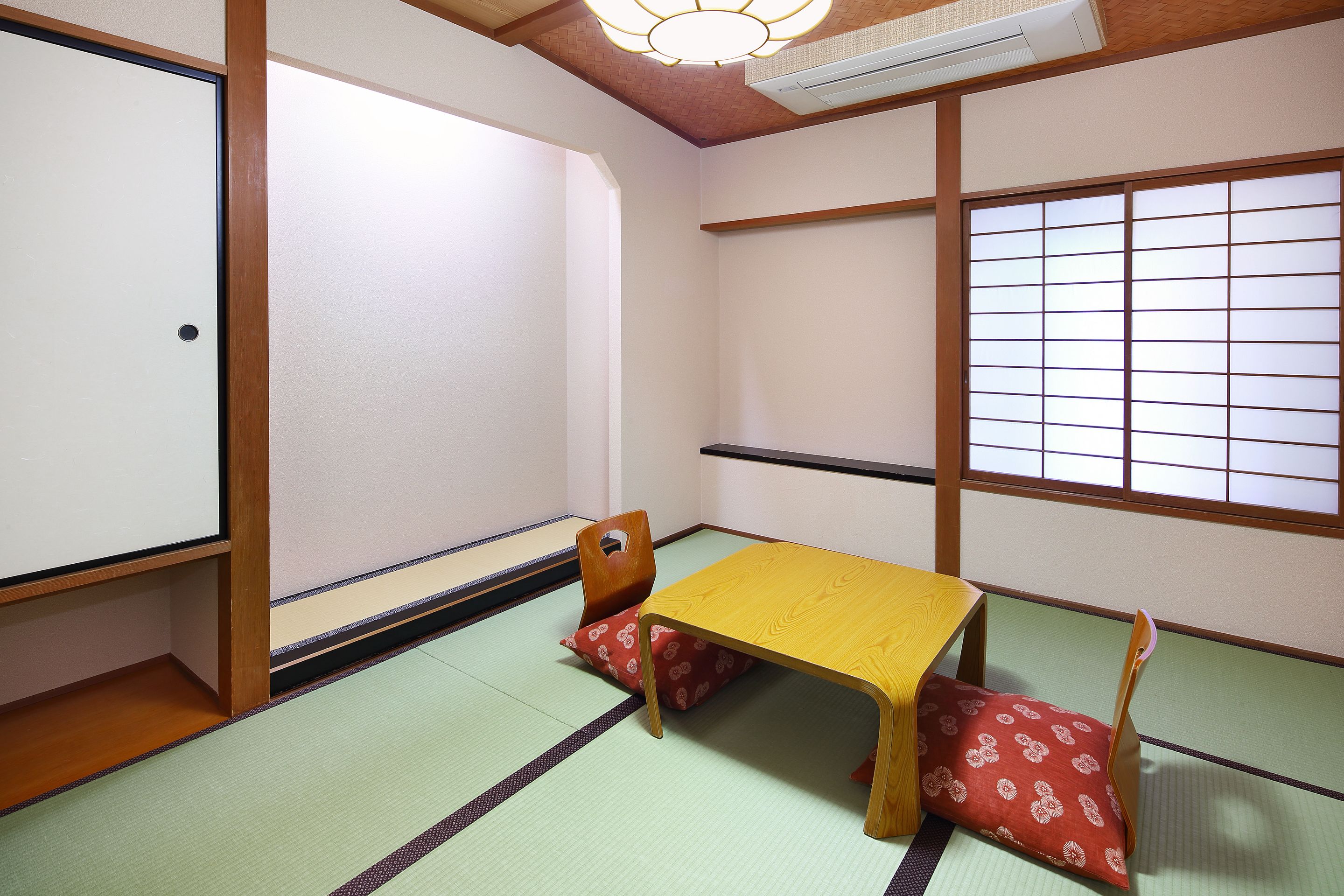 Een traditionele Japanse kamer met tatami vloerbedekking, een lage houten tafel en shoji schuifdeuren.