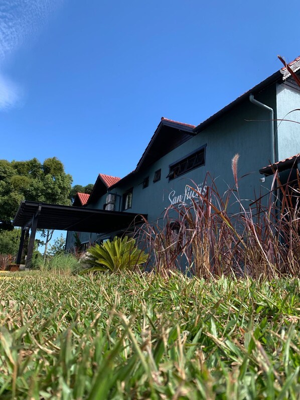 A building with a sign reading "Sun Hotel" and a red roof. - Hotel San Lucas (Gramado)