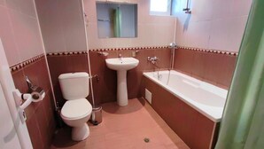 Ein Badezimmer mit Toilette, Waschbecken und Badewanne.