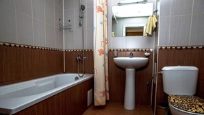 Ein Badezimmer mit Badewanne, Waschbecken, Toilette und Dusche.