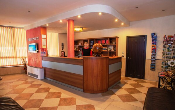 A reception area with a wooden reception desk, a globe, and a TV screen. - Akvaya (Veliko Tarnovo)