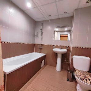 A bathroom with a bathtub, sink, toilet, and shower. - Akvaya (Veliko Tarnovo)