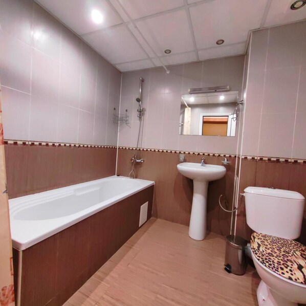 A bathroom with a bathtub, sink, toilet, and shower. - Akvaya (Veliko Tarnovo)