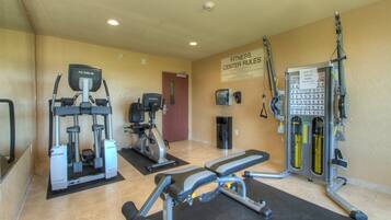 A fitness center with various exercise equipment, including treadmills, a stair climber, and weight machines.