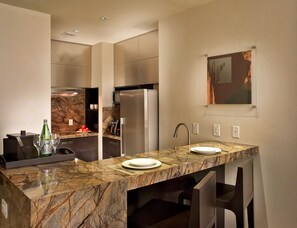 A modern bathroom with a marble countertop, a sink, a mirror, and a built-in shower area.