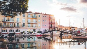 A waterfront building with balconies, a bridge, and boats. -  Le Suffren Hotel, Golfe de Saint-Tropez (Grimaud)