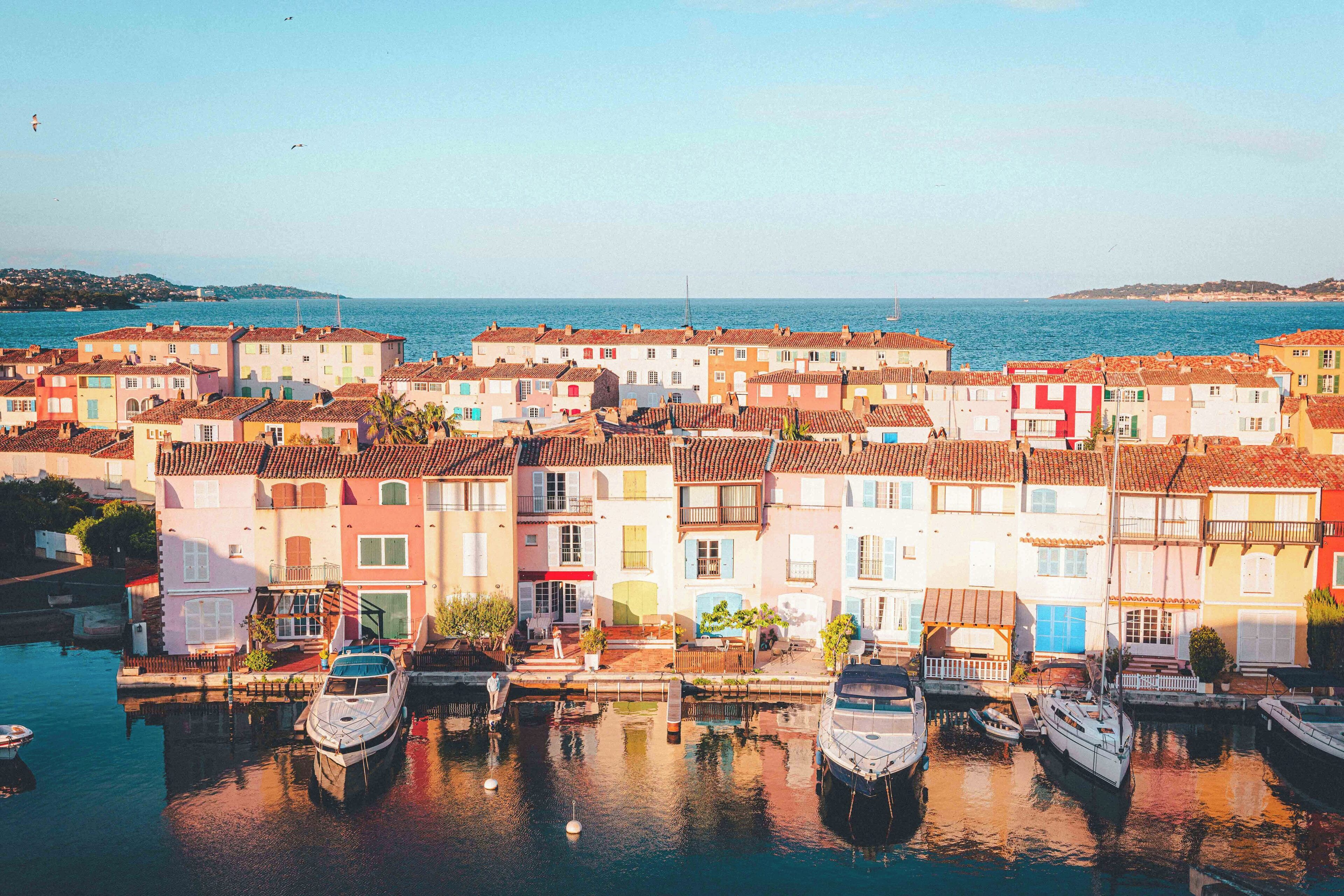 A coastal town with colorful buildings and boats docked in a marina.