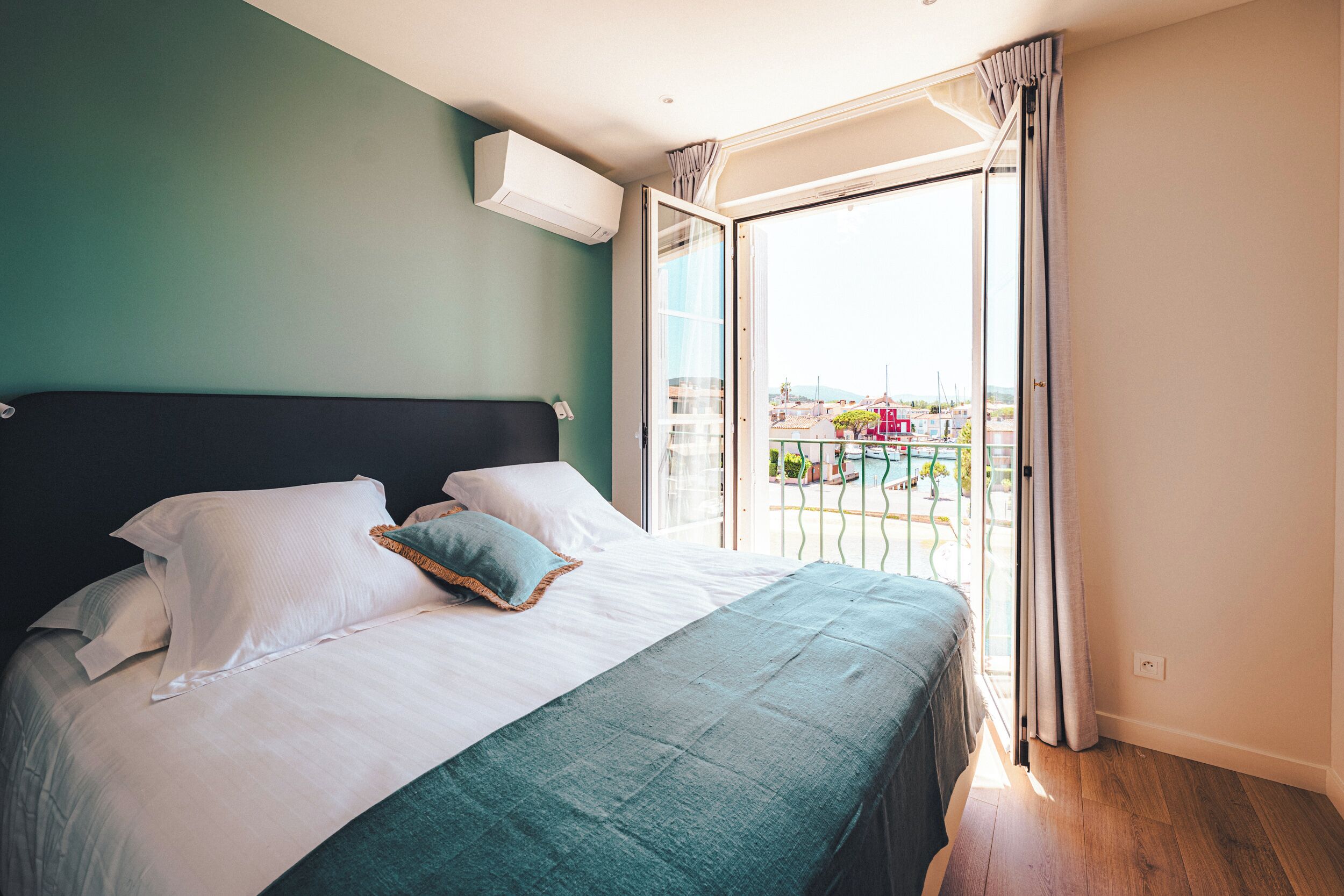 Un dormitorio con cama, ventana y vista al exterior.