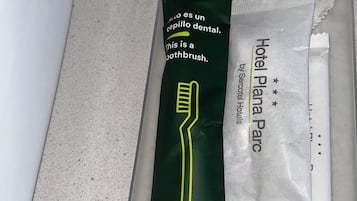 A dental hygiene kit labeled 'Hotel Planar P' by Serotel Hotels, including a toothbrush and a dental floss.