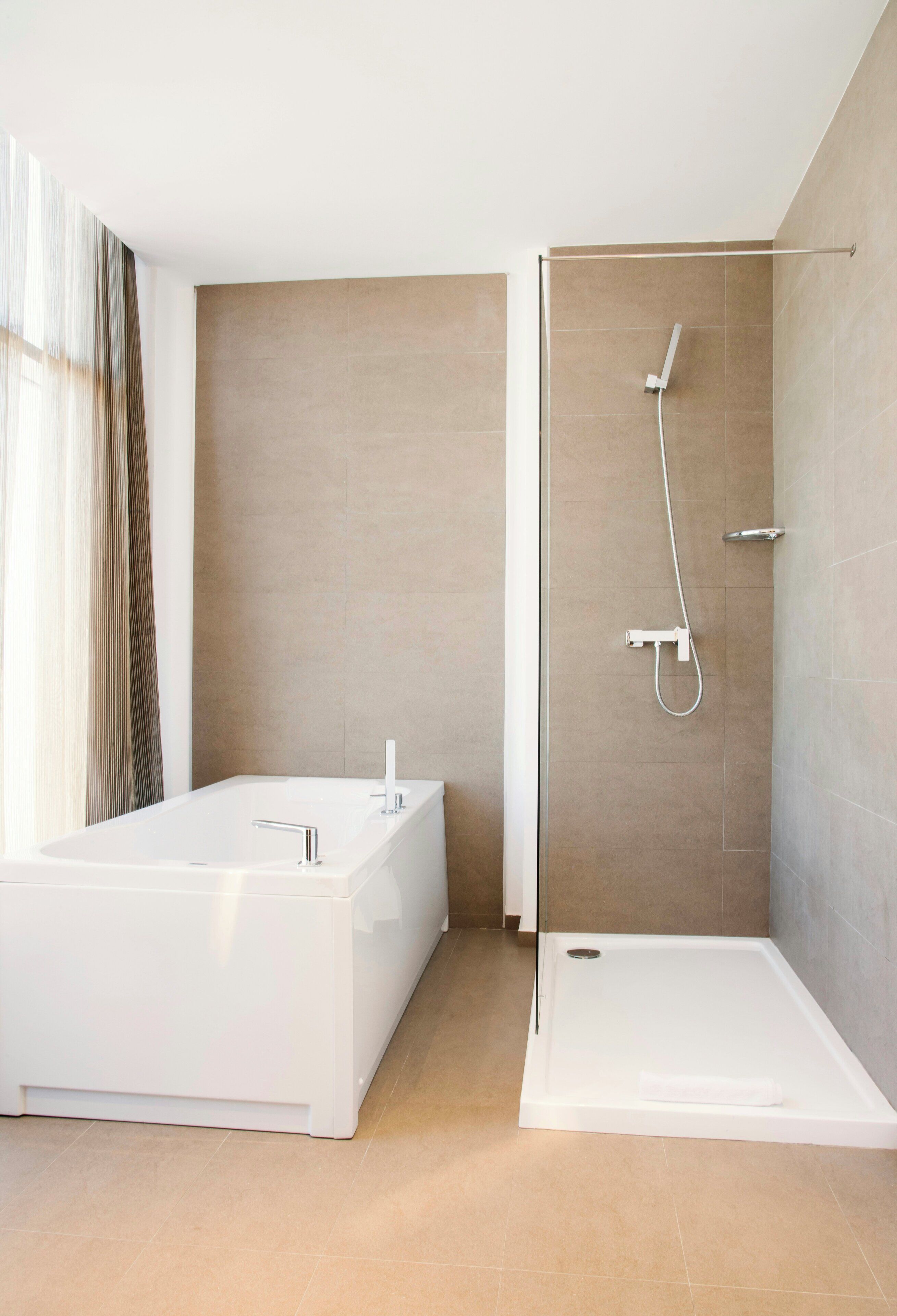 A modern bathroom with a bathtub, shower, and a walk-in shower.