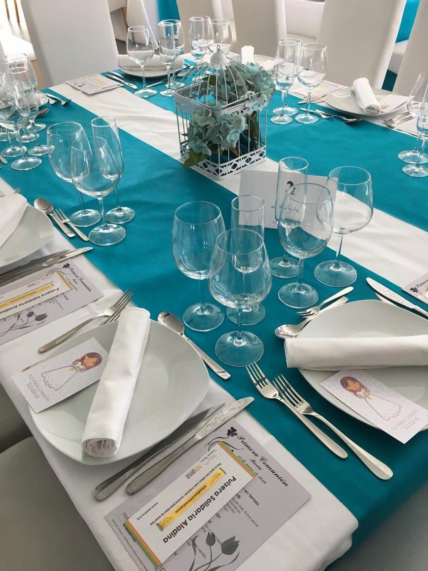 A table set for a formal event with multiple wine glasses, plates, and cutlery.