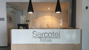 A reception desk with the signage "Sercotel hotels".