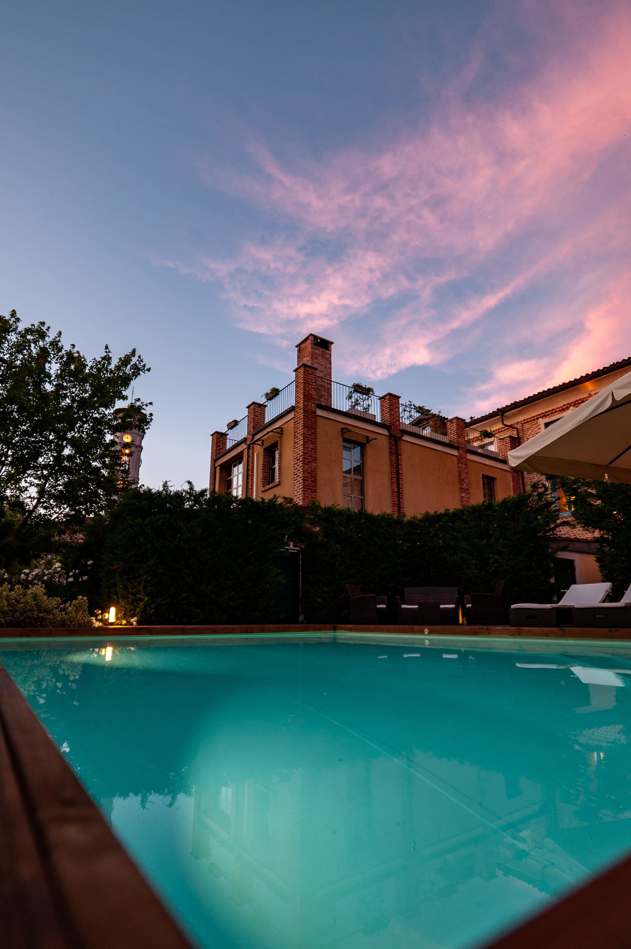 Una piscina con vistas a un edificio de fachada de ladrillo y un balcón.
