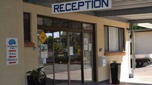 Zona de recepción con un cartel que indica piscina, barbacoa y pérgola.
