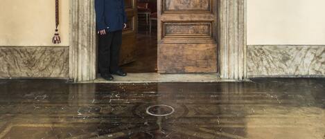 A grand entrance with a wooden door and a sign above it.